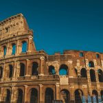 Stunning view of the ancient Roman Colosseum in Rome, Italy, captured at sunset showcasing its historic arches.