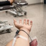 Close-up of a person donating blood in a medical center blood drive.
