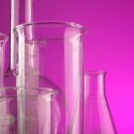 Clear glass laboratory flasks with volume measurements against a vibrant purple backdrop, ideal for science themes.