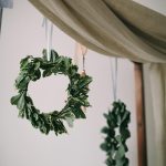 Indoor display of natural greenery wreaths hanging with fabric decoration, creating a serene ambiance.