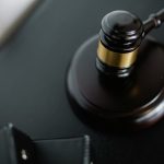 Close-up of a wooden judge's gavel on a black desk, symbolizing justice and law.