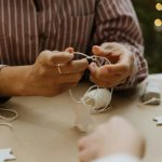 Close-up of hands preparing Christmas star decorations, highlighting creativity and winter festivity.