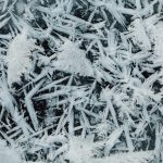 Detailed capture of icy crystals forming intricate patterns of snowflakes.